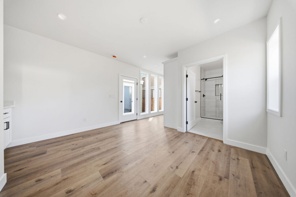 Bright modern room with wood-look vinyl floors and a glass walk-in shower.